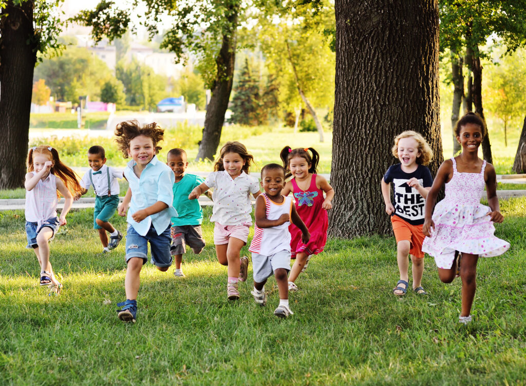 A group of children in a park running towards the camera