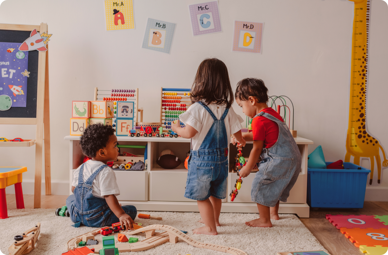 Three young toddlers playing in a playroom