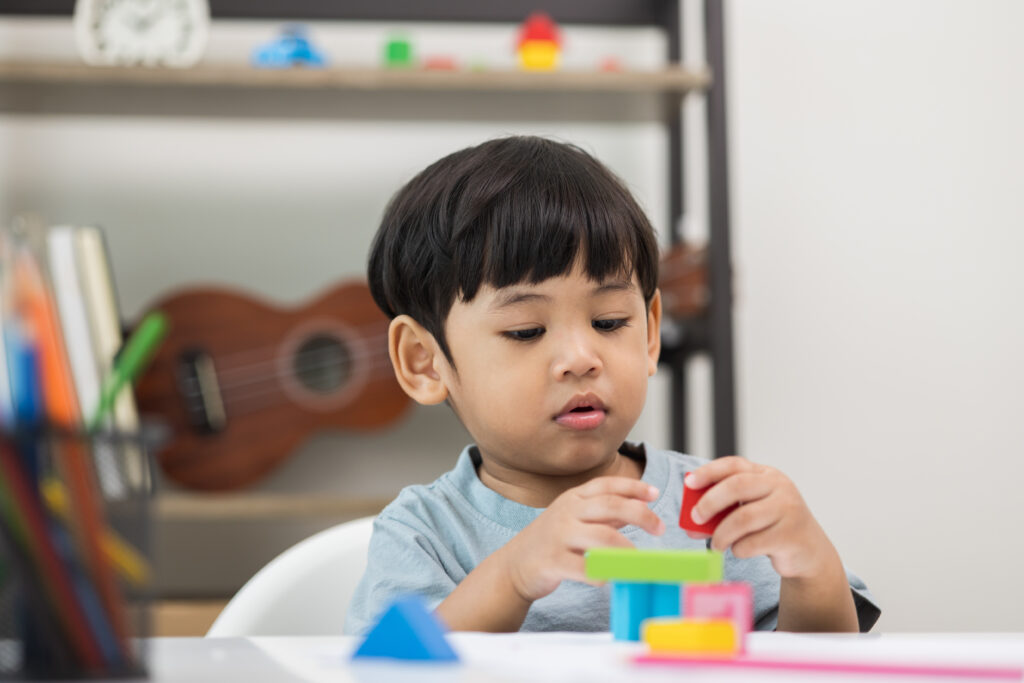 A young boy plays with blocks at a childcare centre