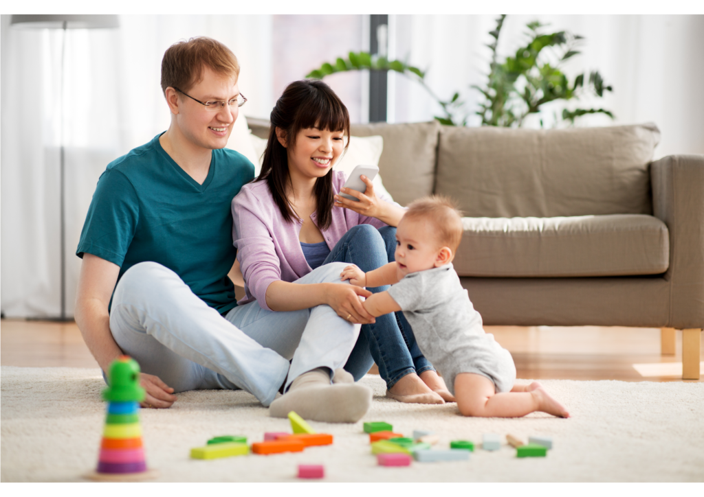 A young family sitting on their living room floor with blocks scattered in the foreground