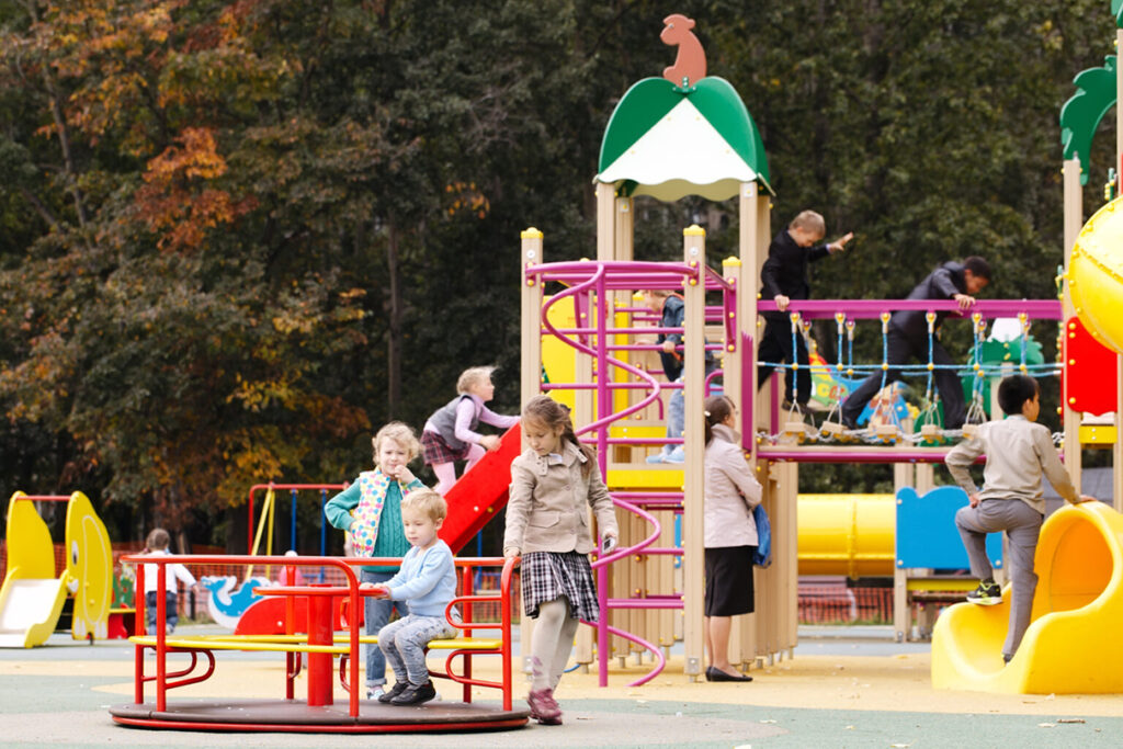 An outdoor playground where children of various ages are engaging in the play they've chosen, and example of them exercising agency in early childhood