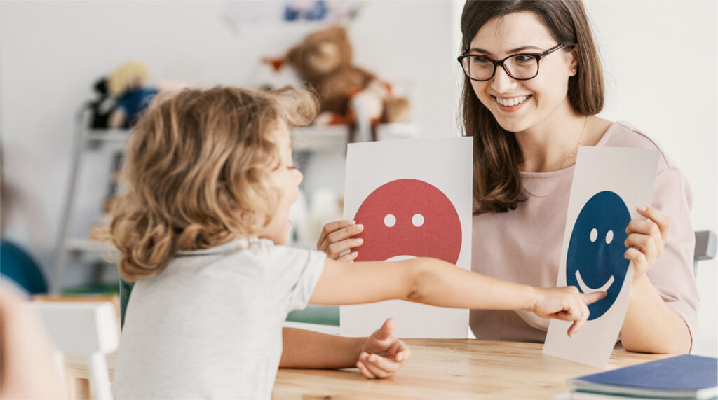 A child points to one of two options held up by a teacher, demonstrating how the teacher is encouraging agency in early childhood