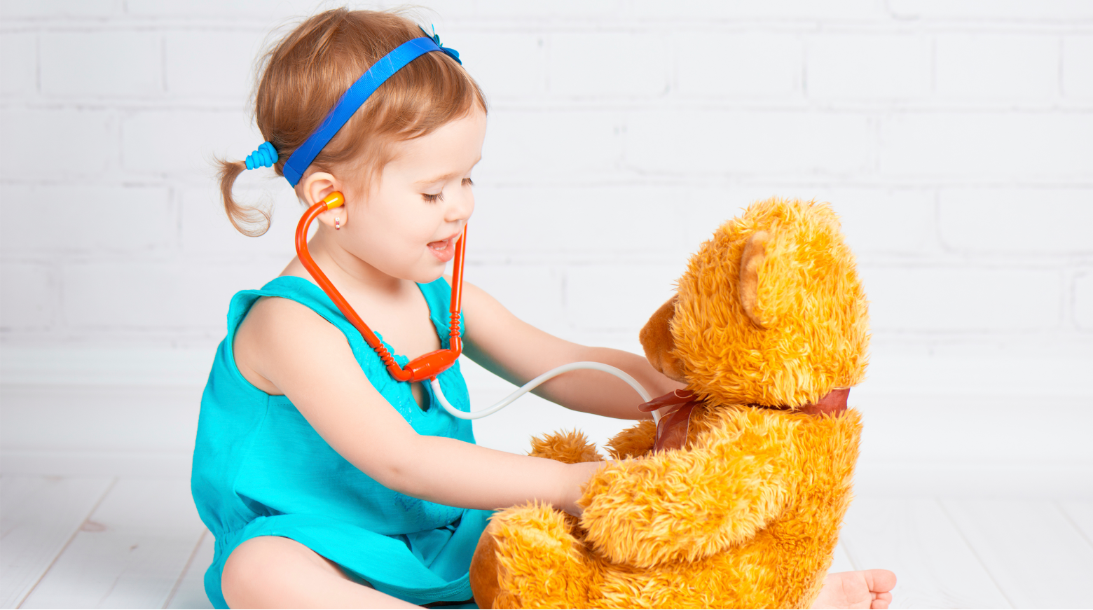 A picture of a young girl playing doctor with her teddy bear, to introduce Quality Area 2 Health & Safety