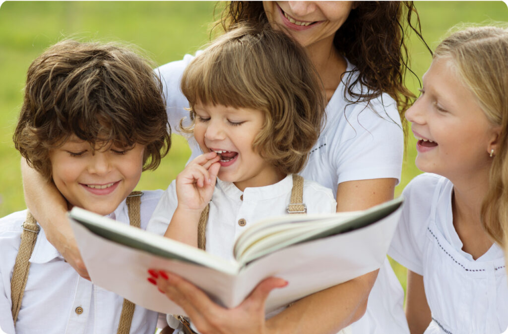 A woman holds a children's book by an Australian author and reads to three smiling children
