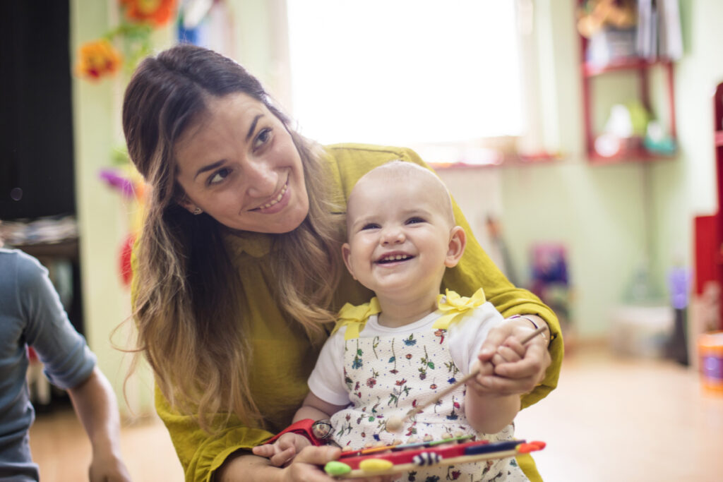 A young woman with a smiling baby in her lap