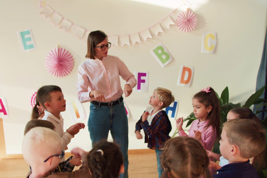 A female educator dancing with several children