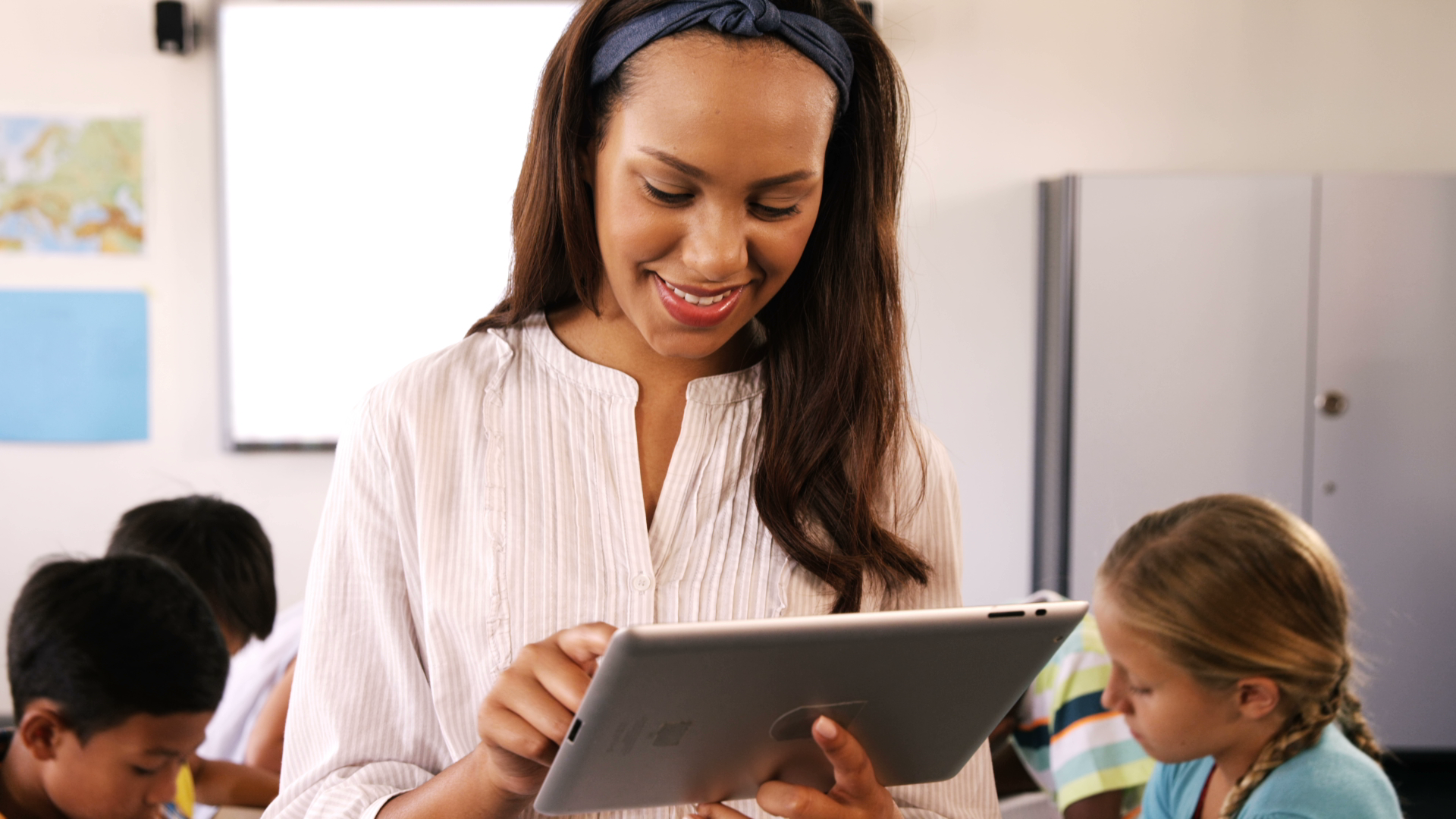 An ECE educator smiles while accessing programming and planning functionality on in Playground on her mobile device