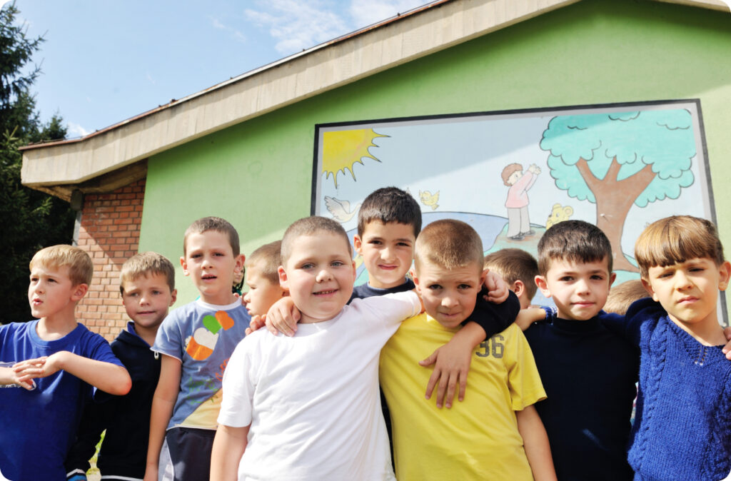 A dozen young boys standing outside, representing childcare staff shortages