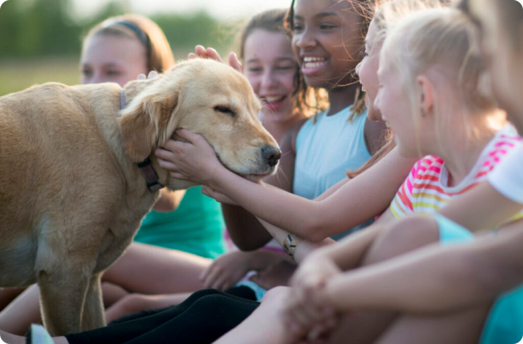 A group of children petting a golden retriever