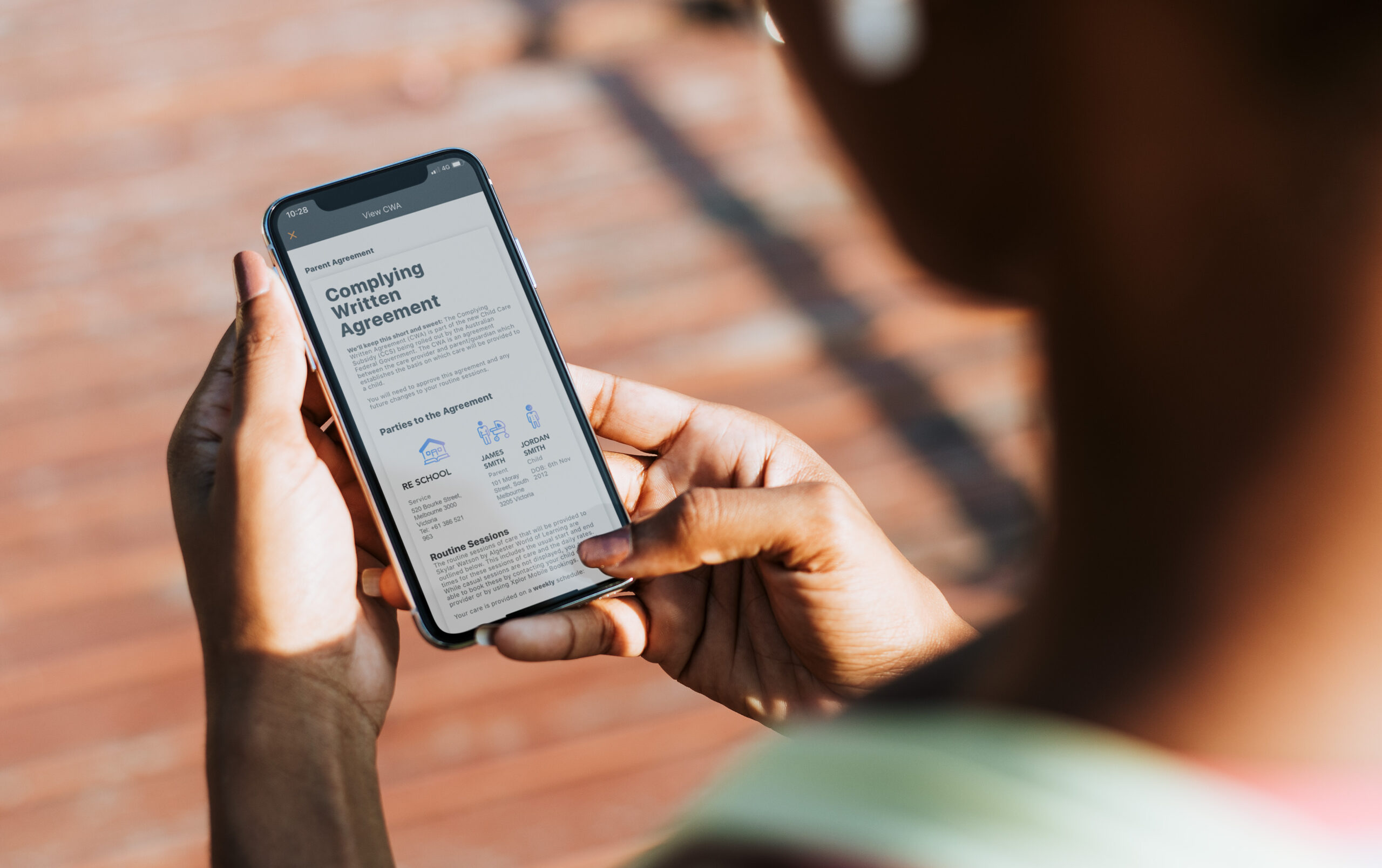 A mother reviews a Complying Written agreement on her smart phone.
