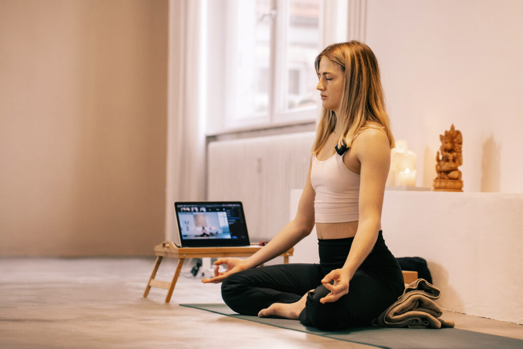 A young woman meditating, one of several effective strategies for preventing teacher burnout in early childhood education