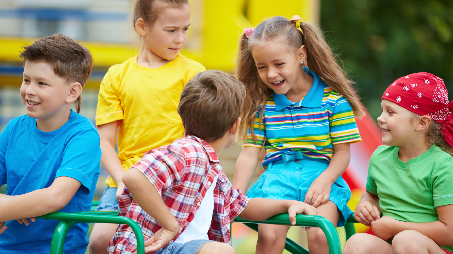 Young children on a roundabout in a playground, a key location for playful learning